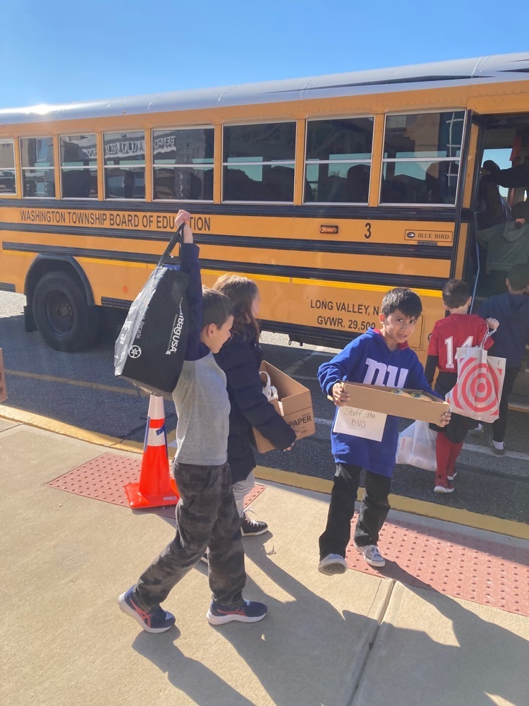 Students carrying donated items to the bus.