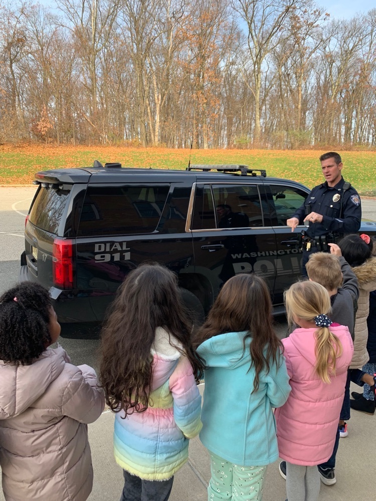Officer Feicther showing off the police car to students